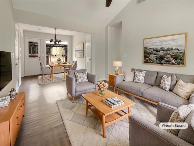 living room with an inviting chandelier and vaulted ceiling