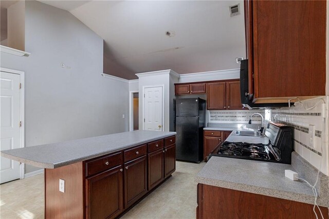 kitchen with backsplash, vaulted ceiling, sink, black appliances, and a kitchen island