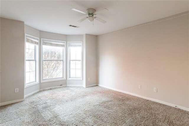 carpeted spare room featuring ceiling fan