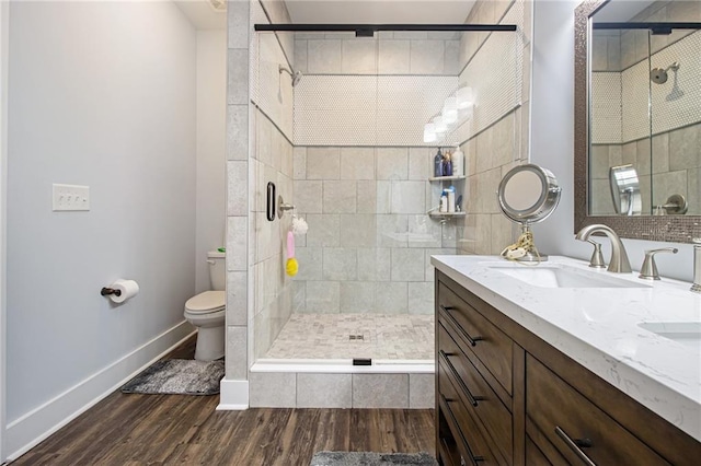 bathroom featuring wood-type flooring, an enclosed shower, vanity, and toilet