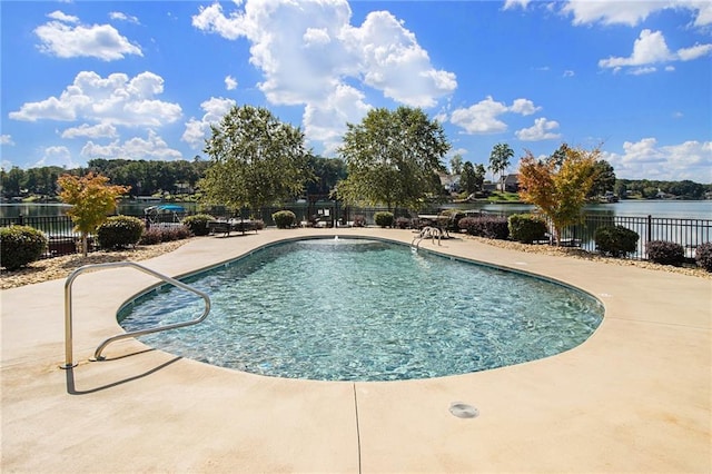 view of pool with a patio and a water view