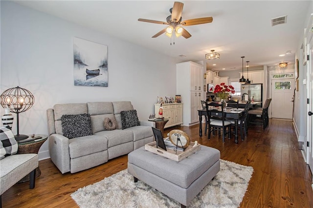 living room featuring ceiling fan and dark wood-type flooring