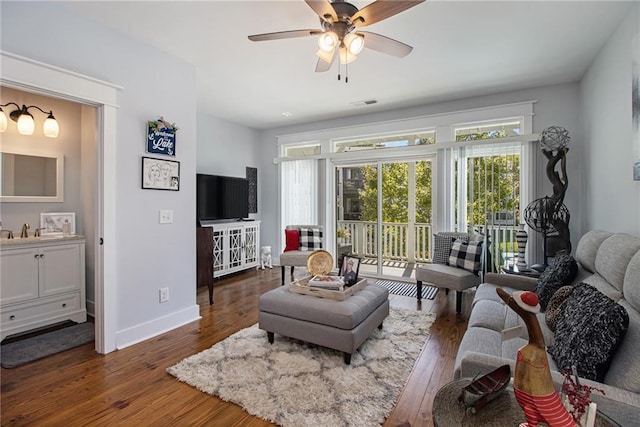 living room featuring dark hardwood / wood-style floors, ceiling fan, and sink