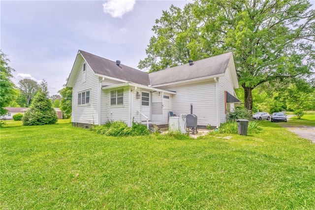 back of property with a yard and entry steps