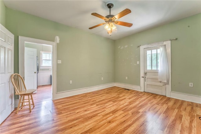 spare room featuring healthy amount of natural light, light wood-style floors, and a ceiling fan