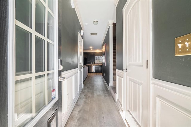 hallway featuring hardwood / wood-style floors and crown molding