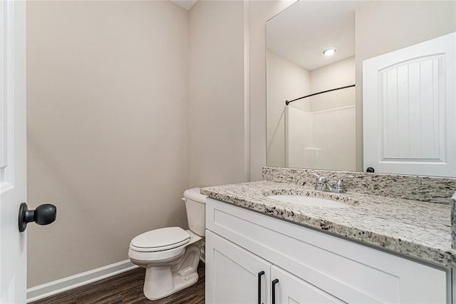 bathroom with walk in shower, wood-type flooring, toilet, and vanity