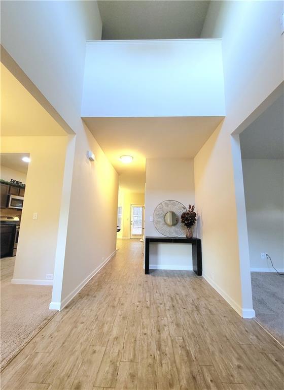 hall featuring a towering ceiling and hardwood / wood-style flooring