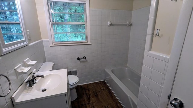 2569 Dobbs Dr NW, Kennesaw, GA 30152 - bathroom featuring tile walls, toilet, wood finished floors, vanity, and wainscoting