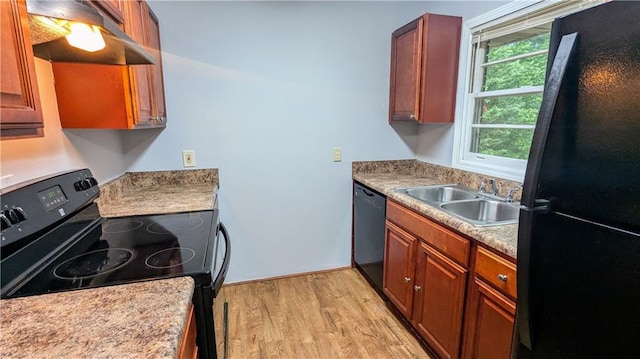 2569 Dobbs Dr NW, Kennesaw, GA 30152 - kitchen with black appliances, a sink, under cabinet range hood, light wood-type flooring, and brown cabinetry