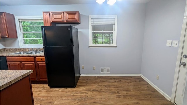 2569 Dobbs Dr NW, Kennesaw, GA 30152 - kitchen with black appliances, a sink, light wood-type flooring, light countertops, and baseboards