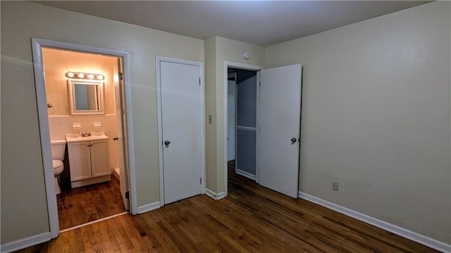 2569 Dobbs Dr NW, Kennesaw, GA 30152 - unfurnished bedroom featuring wood finished floors, a sink, ensuite bathroom, and baseboards