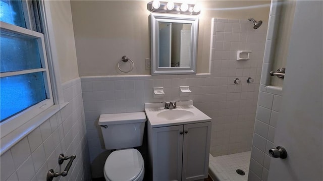 2569 Dobbs Dr NW, Kennesaw, GA 30152 - bathroom with a tile shower, toilet, vanity, tile walls, and a wainscoted wall