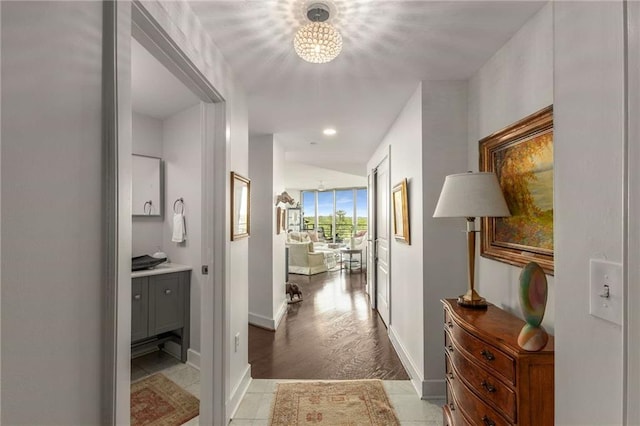 hallway featuring baseboards, recessed lighting, and a chandelier