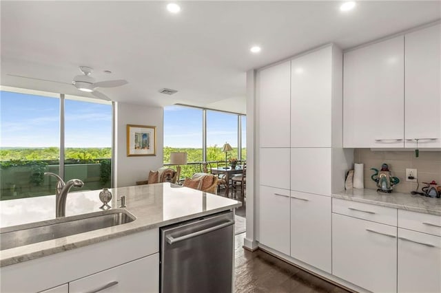 kitchen with a wall of windows, decorative backsplash, a wealth of natural light, and dishwasher