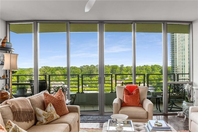 sunroom with plenty of natural light, wood finished floors, and expansive windows
