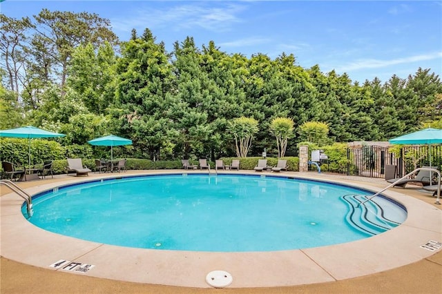 community pool featuring fence and a patio area