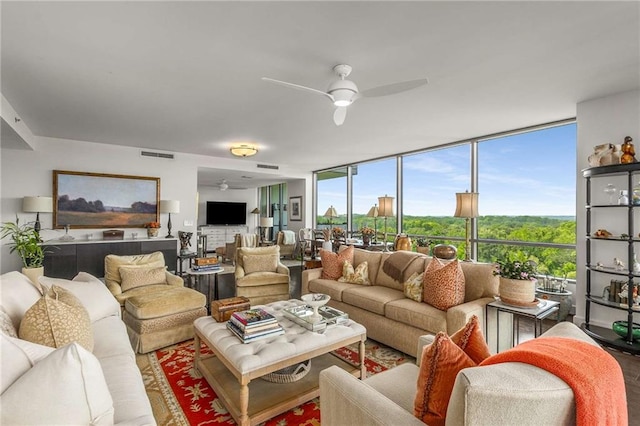 living room featuring ceiling fan, visible vents, and a wall of windows