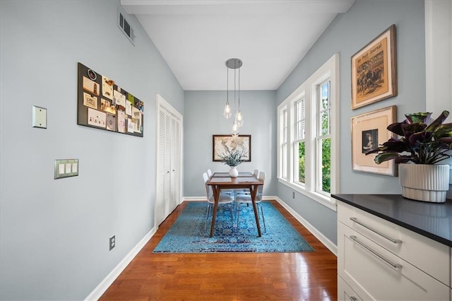 dining space featuring dark wood finished floors, baseboards, and visible vents