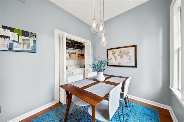 dining space featuring washer / clothes dryer, wood finished floors, and baseboards