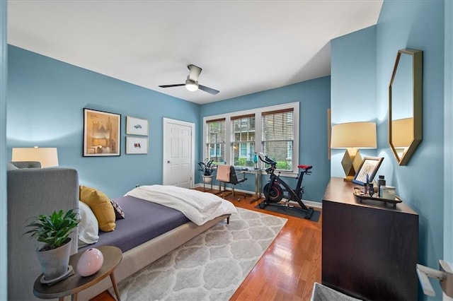 bedroom with wood finished floors, baseboards, and ceiling fan