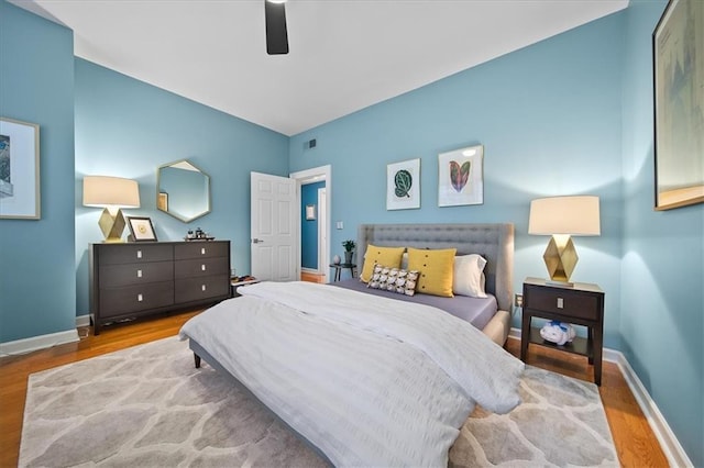 bedroom with visible vents, wood finished floors, and baseboards