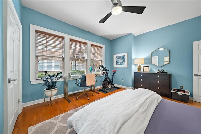 bedroom with a ceiling fan, baseboards, and wood finished floors