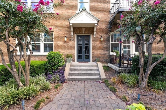 view of exterior entry with brick siding and french doors