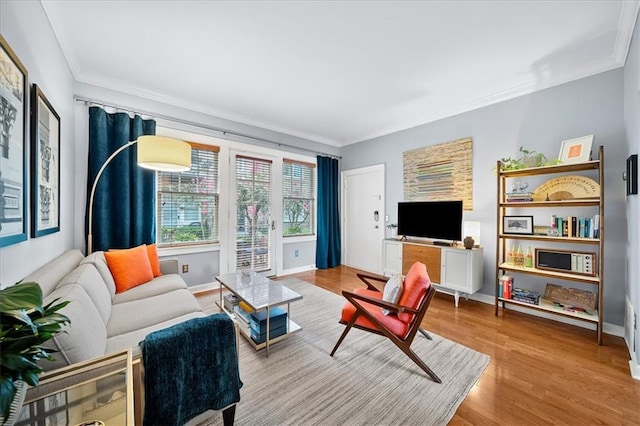 living area with ornamental molding, baseboards, and wood finished floors