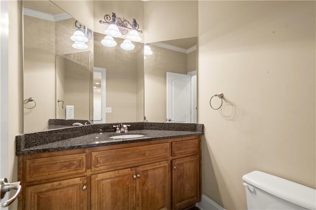 bathroom with toilet, vanity, and crown molding