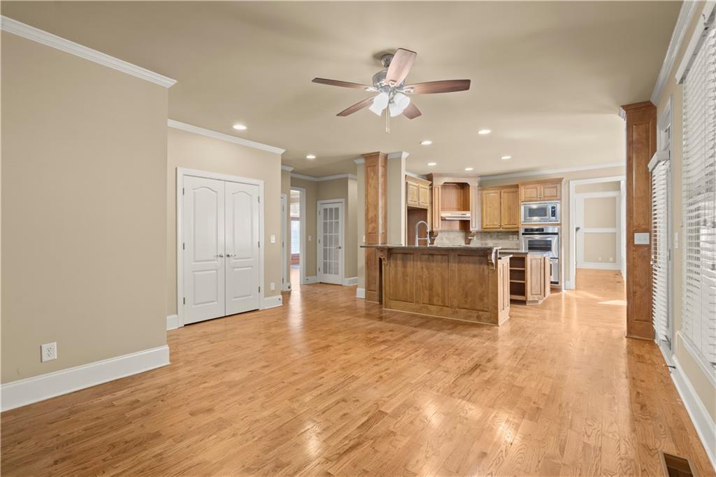 kitchen featuring appliances with stainless steel finishes, a center island, ornamental molding, ceiling fan, and a breakfast bar