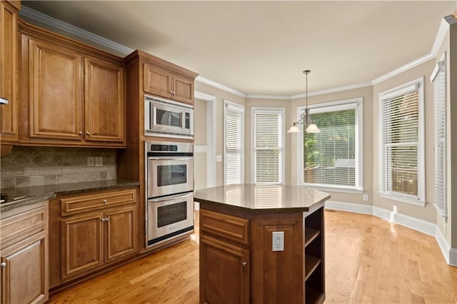 kitchen featuring light hardwood / wood-style floors, a kitchen island, decorative backsplash, crown molding, and stainless steel appliances