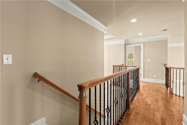 hallway with light hardwood / wood-style floors and ornamental molding