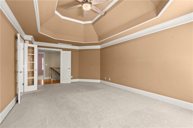 carpeted spare room featuring ceiling fan, crown molding, french doors, and a tray ceiling