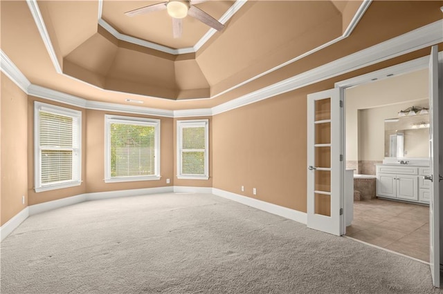 carpeted empty room with ceiling fan, french doors, a tray ceiling, and ornamental molding