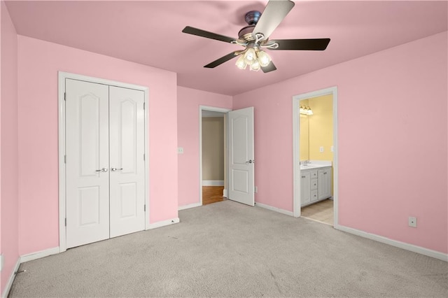 unfurnished bedroom featuring connected bathroom, ceiling fan, a closet, and light colored carpet