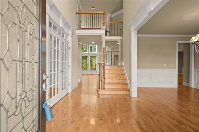 entrance foyer with a high ceiling, hardwood / wood-style floors, and crown molding