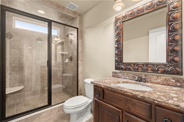 bathroom with tile patterned floors, toilet, vanity, and walk in shower