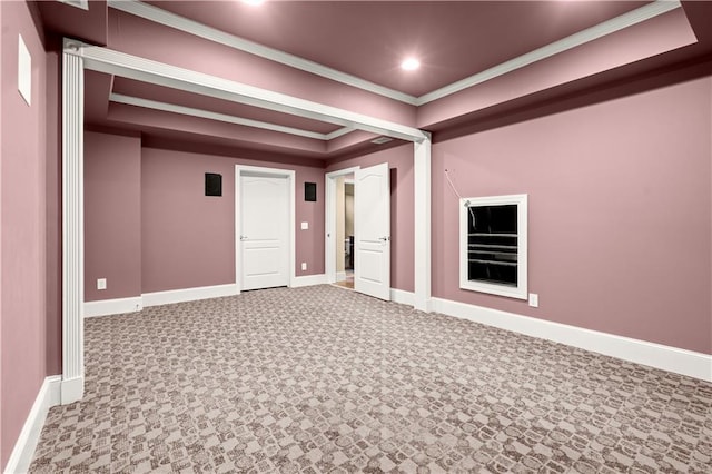 carpeted empty room with a tray ceiling and ornamental molding