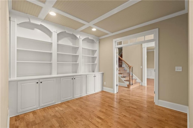 unfurnished dining area with built in shelves, coffered ceiling, ornamental molding, and light wood-type flooring