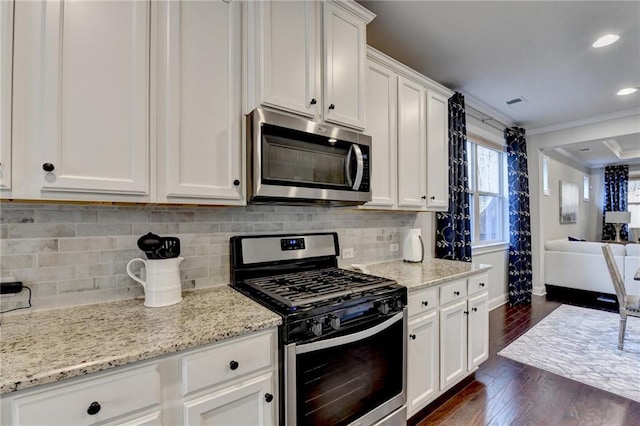 kitchen featuring tasteful backsplash, appliances with stainless steel finishes, white cabinets, crown molding, and dark wood-style flooring