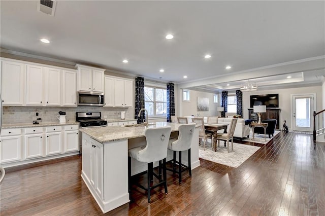 kitchen with dark wood-style flooring, visible vents, a wealth of natural light, and stainless steel appliances