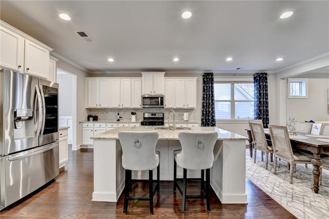 kitchen featuring crown molding, tasteful backsplash, visible vents, and appliances with stainless steel finishes