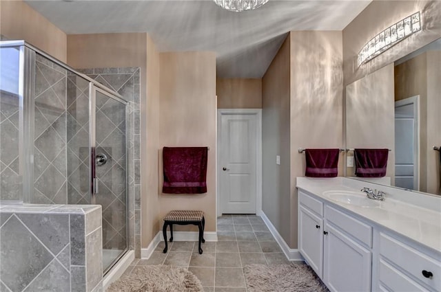 full bath featuring tile patterned flooring, a stall shower, vanity, and baseboards