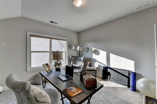 office area with visible vents, carpet floors, baseboards, and vaulted ceiling