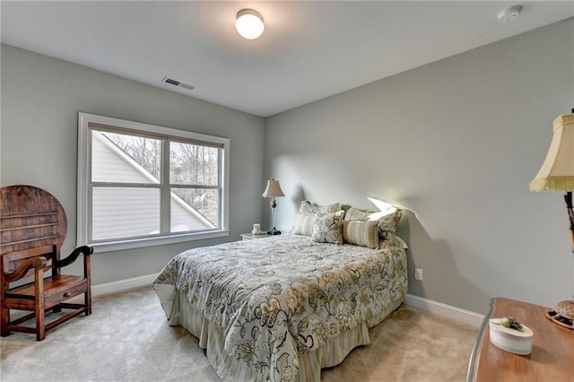 bedroom featuring baseboards, visible vents, and light carpet