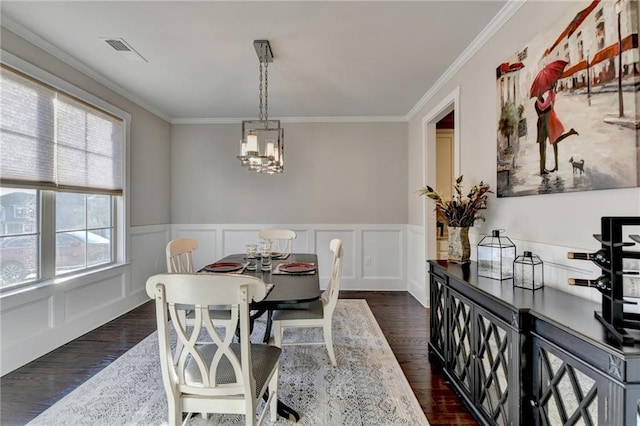 dining space with dark wood-type flooring, a decorative wall, crown molding, and visible vents