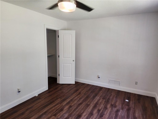 spare room featuring ceiling fan and dark hardwood / wood-style floors