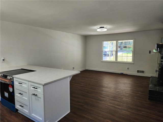 kitchen featuring dark hardwood / wood-style flooring, white cabinetry, stainless steel range with electric cooktop, and light stone countertops