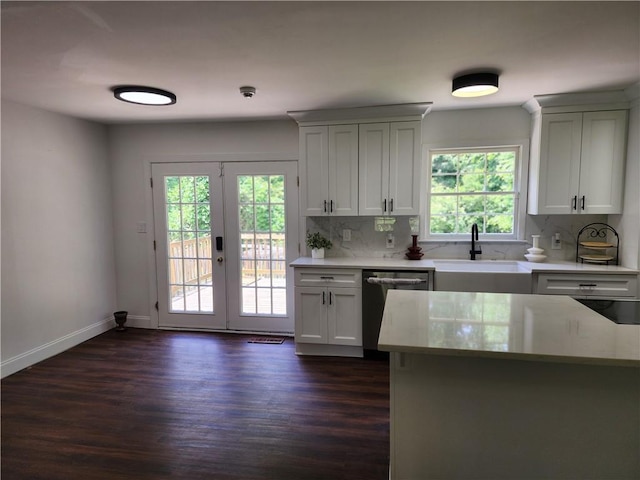 kitchen with dishwasher, dark hardwood / wood-style flooring, french doors, white cabinets, and sink